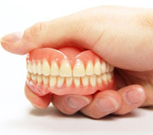 denture smile in hand